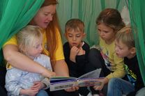 Kinder entspannen mit Übungsleiterin beim Vorlesen