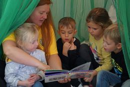 Kinder entspannen mit Übungsleiterin beim Vorlesen