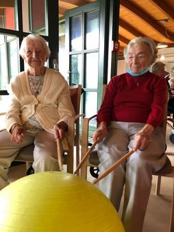 Seniorinnen mit Drum-Sticks, die auf einen Gymnastikball schlagen