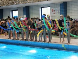 Kinder stehen mit Nudel am Beckenrand