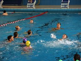 Damian Wierling schwimmt mit Kindern im Wasser