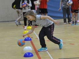 Kind übt Prellen mit dem Handball